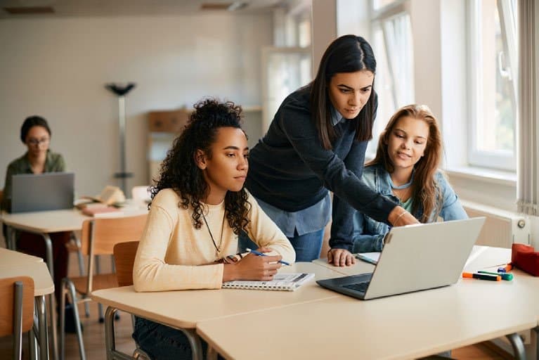 Professora orientando estudantes em atividade colaborativa de aprendizagem