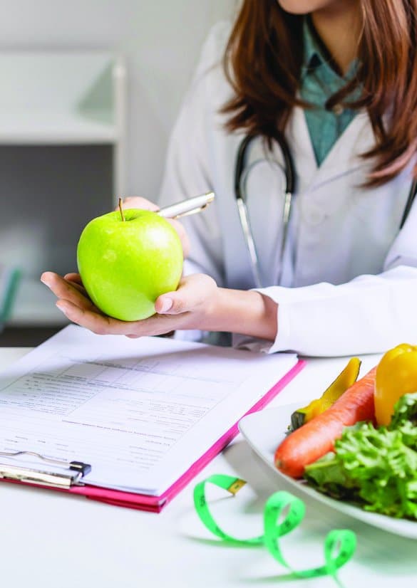 Profissional da nutrição avaliando alimentos e orientações dietéticas