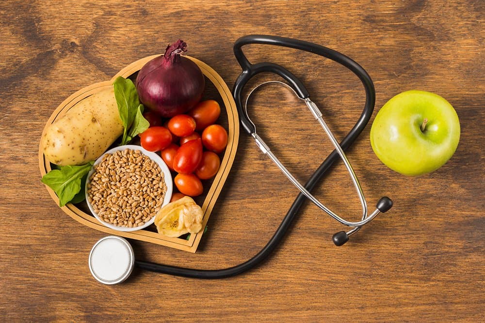 Alimentos saudáveis e estetoscópio representando nutrição clínica