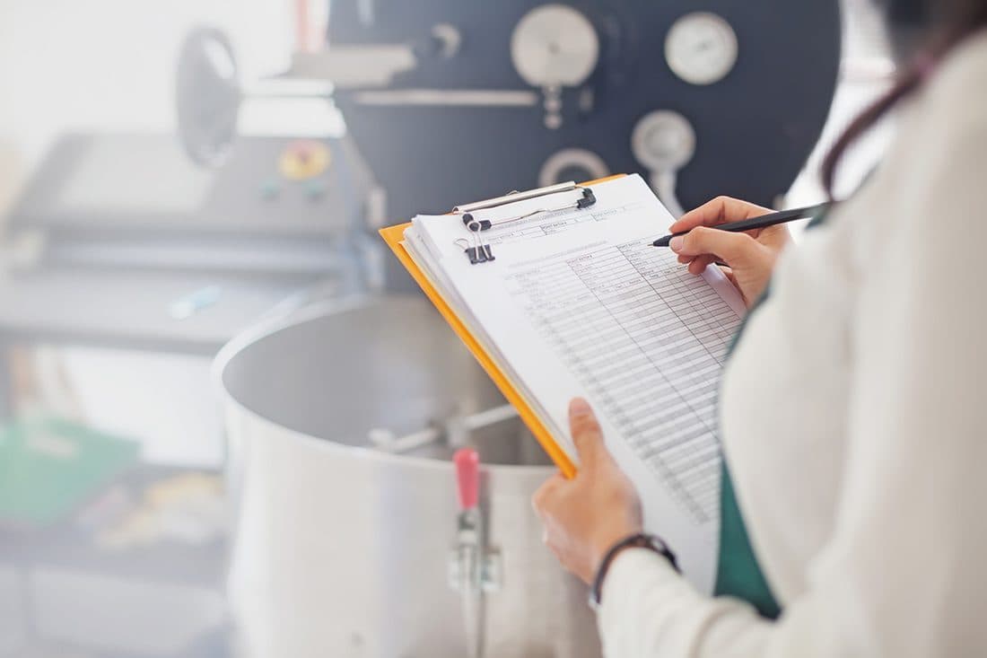 Profissional realizando inspeção sanitária em ambiente de produção de alimentos